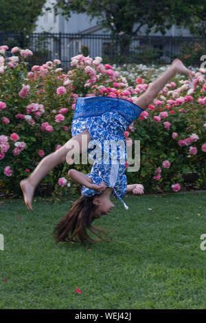 Preteen girl d'apparence asiatique faisant la gymnastique au rose garden, San Jose, Californie Banque D'Images