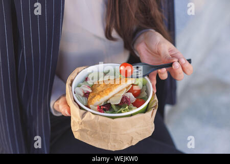 Salade dans un déjeuner d'affaires. Mains de business woman holding de légumes grillés et de la fourchette. Banque D'Images