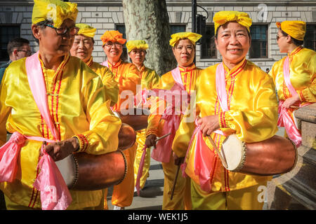 Londres, Royaume-Uni. 30 août 2019. Une goup de tambours de taille dans les costumes brillants pratique leur routine. Les praticiens du mouvement spirituel Falun Gong chinois (également connu sous le nom de Falun Dafa) occupent la place du Parlement et les environs et participent à une pratique de masse de leurs compétences. Les participants viennent de toute l'Europe avant une conférence à Londres demain. Crédit : Imagetraceur/Alamy Live News Banque D'Images