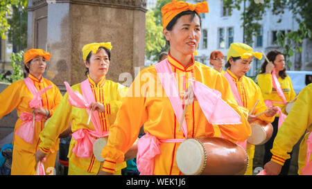 Londres, Royaume-Uni. 30 août 2019. Une goup de tambours de taille dans les costumes brillants pratique leur routine. Les praticiens du mouvement spirituel Falun Gong chinois (également connu sous le nom de Falun Dafa) occupent la place du Parlement et les environs et participent à une pratique de masse de leurs compétences. Les participants viennent de toute l'Europe avant une conférence à Londres demain. Crédit : Imagetraceur/Alamy Live News Banque D'Images