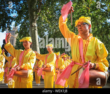 Londres, Royaume-Uni. 30 août 2019. Une goup de tambours de taille dans les costumes brillants pratique leur routine. Les praticiens du mouvement spirituel Falun Gong chinois (également connu sous le nom de Falun Dafa) occupent la place du Parlement et les environs et participent à une pratique de masse de leurs compétences. Les participants viennent de toute l'Europe avant une conférence à Londres demain. Crédit : Imagetraceur/Alamy Live News Banque D'Images