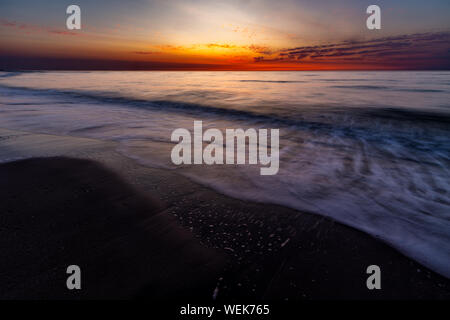 Ciel coloré sur la mer du Nord après le coucher du soleil sur la plage de Juist, îles de la Frise orientale, en Allemagne. Banque D'Images