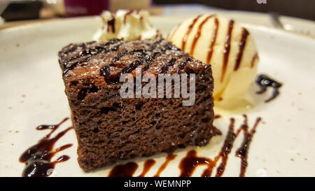 Brownies au chocolat avec de la crème glacée vanille sur un disque blanc dans le restaurant Banque D'Images