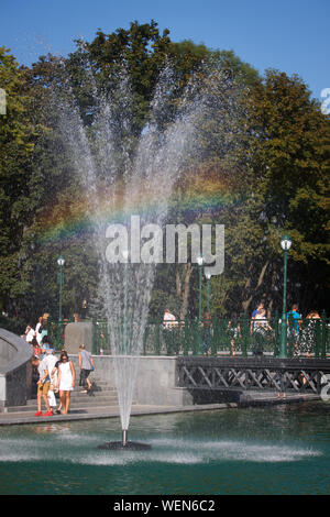 Kharkiv, Ukraine - le 20 août 2019 : les gens marchent dans un parc public sur le contexte des jets d'une fontaine et d'un arc-en-ciel, l'idée de la lumière en t Banque D'Images