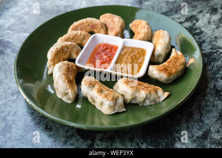 Cuisine asiatique traditionnelle. Fried dumpling népalais momo servi avec Chutney de tomates. Banque D'Images