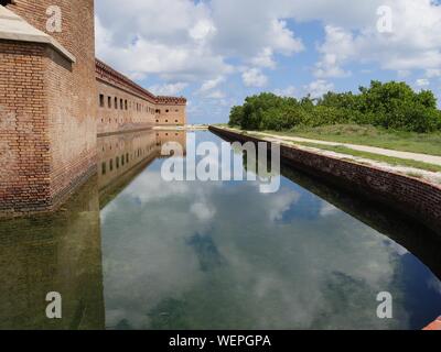 Les nuages magnifiques reflétés dans les douves entourant Fort Jefferson, le parc national sec de Tortugas en Floride. Banque D'Images