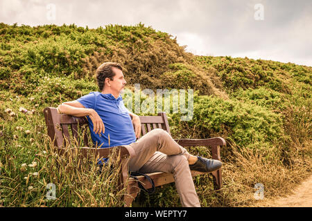 Homme assis sur un banc en bois, penser à penser à l'avenir Banque D'Images