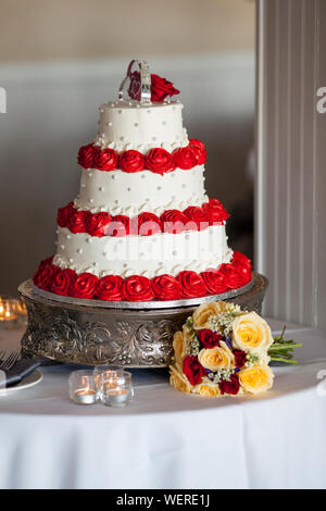 Gâteau de mariage à trois niveaux avec rose rouge confection Banque D'Images