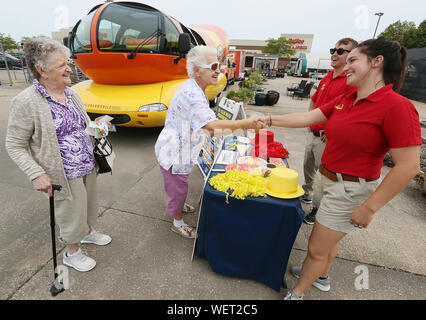 Oqasmieh, Iowa, États-Unis. Août 30, 2019. Edy Rousselow de Moline, serre la main avec Alexandra Hancher après avoir découvert les lecteurs Hancher Oscar Mayer Weinermobile Hy-Vee au sur la 5e Rue, dans l'Illinois Chikar dans Vendredi, 30 août 2019. Rousselow et ami Donna Anderson, gauche de Cordova a indiqué qu'ils avaient vu d'autres versions de l'Weinermobile en 1958 et 1969. Crédit : Kevin E. Schmidt/Quad-City Times/ZUMA/Alamy Fil Live News Banque D'Images