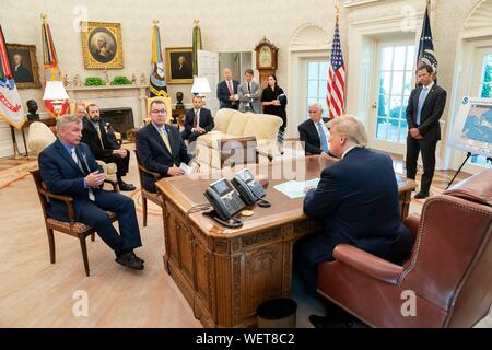 Washington, DC, USA. 29 août 2019. Le Président américain Donald Trump, rejoint par le Vice-président Mike Pence, reçoit un exposé sur l'Ouragan Dorian dans le bureau ovale de la Maison Blanche le 29 août 2019. La prévision actuelle appelle à Dorian pour renforcer au-dessus de l'eau à une catégorie 4 avec des vents de 140 mph avant de prendre les côtes de Floride du Sud fin lundi. Credit : Shealah Planetpix Craighead//Alamy Live News Banque D'Images