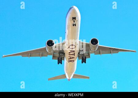 Un Boeing 777 de Qatar Airways en approche finale à New York avec roues vers le bas et bleu ciel derrière Banque D'Images