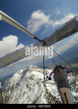 Pilote courageux voler plus de sommet de montagne cobered par la neige sur un planeur. Sport aérien extrême. Deltaplane Banque D'Images