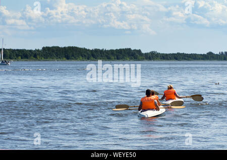 Deux kayaks sur le lac vue vers l'arrière. Les canoéistes vêtus de gilets orange. Banque D'Images