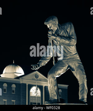 Elvis Presley statue en bronze posent avec microphone et de main tendue, dans la nuit, par l'Hôtel de Ville de Tupelo de Tupelo, MS, États-Unis d'Amérique, en sélénium tone Banque D'Images