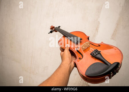 Un ancien violon acoustique dans un vieux décor ou dans le ciel qui s'est tenue à mains Banque D'Images