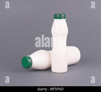 Bouteille en plastique blanc avec du lait, du yaourt ou kéfir, sur un fond gris. Template design maquette sans étiquette. Banque D'Images