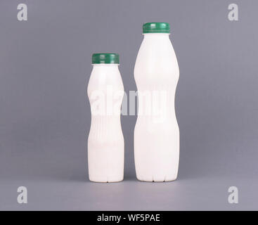 Bouteille en plastique blanc avec du lait, du yaourt ou kéfir, sur un fond gris. Template design maquette sans étiquette. Banque D'Images