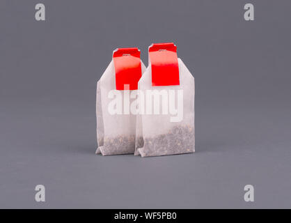Close-up sachet à thé avec étiquette rouge sur fond gris des maquettes. Banque D'Images