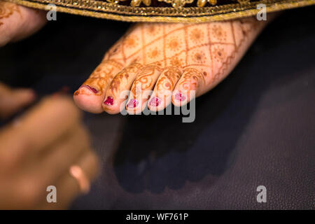 Mariée indienne pieds avec coloration au henné indien ou coller des tatouages symboliques conception mehndi lors d'une cérémonie de mariage hindou - Image Banque D'Images