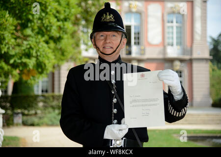 Trier, Allemagne. Août 28, 2019. Johannes Schneider présente la lettre de félicitations de la reine Elizabeth II et le Prince Charles. Pendant 25 ans, il a été sur la route qu'un doctorat bobby pour la ville de Trèves de partenariat avec Gloucester. (Dpa "depuis 25 ans sur la route à titre de bobby') Credit : Harald Tittel/dpa/Alamy Live News Banque D'Images