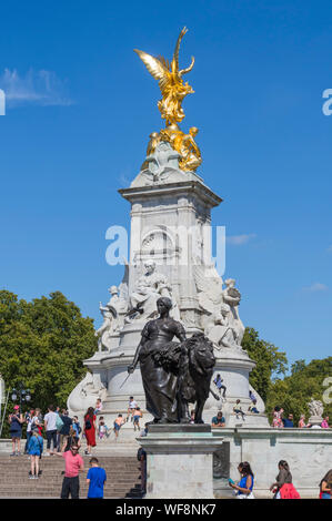 Les touristes à la statue en or sur le Queen Victoria Memorial à Buckingham Palace, Westminster, Londres, Angleterre, Royaume-Uni. Banque D'Images