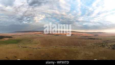 Panorama des plaines ouvertes de la Masai Mara au petit matin, avec la rivière Mara qui serpente à travers les collines, et de l'escarpement du Oldoinyio. Vue aérienne Banque D'Images