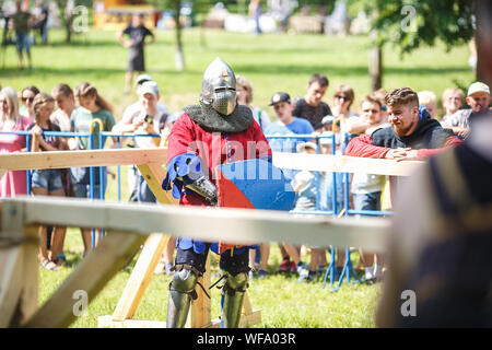 Minsk, Belarus - Juin 2019 : medieval jousting combat du cavalier, en armure, casques, chain mail avec des haches et des épées sur des listes d'une reconstruction historique. Banque D'Images