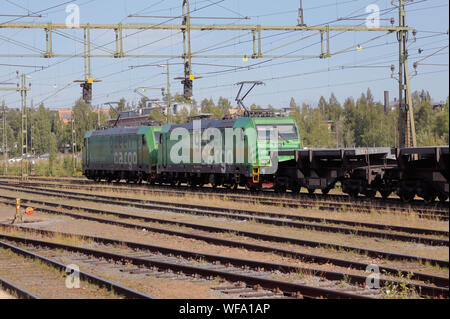 Vaxjo, Suède - 20 août 2019 : Deux Green Cargo electric locomitives re classe tirant sur wagons plats chargés d'acier de l'usine sidérurgique SSAB à proximité Banque D'Images