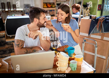 Jeune homme et femme partenaires se tiennent dans leur nouveau café et de travail d'ouvrir. Banque D'Images
