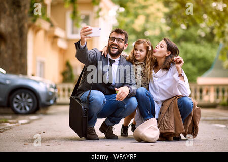 Fille et les parents d'élèves heureux après la première journée d'école est plus de faire une photo, Banque D'Images