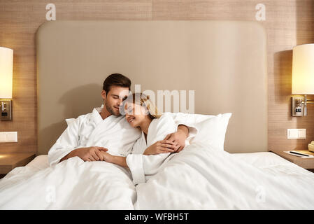 Portrait de couple allongé sur le lit et la tenue de l'autre. Voyageant ensemble concept. Plan horizontal. Vue avant Banque D'Images