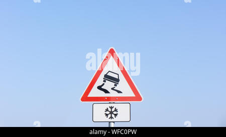 Panneau de circulation lance un avertissement sur route glissante de l'avant Banque D'Images