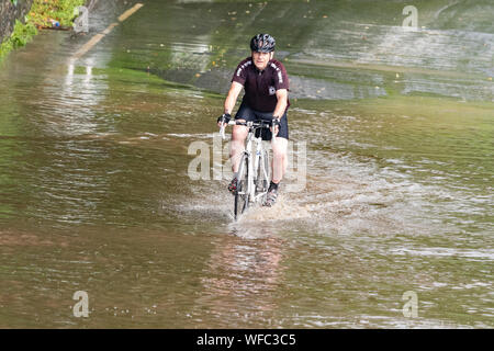 Bardowie, Glasgow, Ecosse, Royaume-Uni. Août 31, 2019. Royaume-uni - un cycliste déterminée continue son trajet matin quel que soit des sections d'inondations dues à de fortes pluies la nuit et averses ce matin à Glasgow Crédit : Kay Roxby/Alamy Live News Banque D'Images