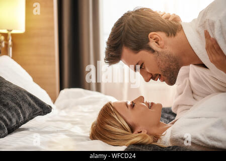 Portrait de couple allongé sur le lit et à la recherche à l'autre. Voyageant ensemble concept. Plan horizontal. Vue de côté Banque D'Images