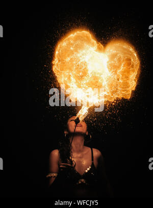Woman Blowing forme de coeur d'artifice dans la nuit