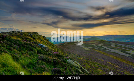 Win Hill, UK - Aug 12, 2019 : coucher de soleil sur le Peak District à partir de Win Hill avec les débuts de Heather d'épanouissement. Banque D'Images
