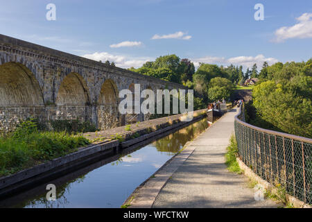 15-04 et les marcheurs traverser l'aqueduc sur le canal de Llangollen construit en 1801 avec le viaduc de chemin de fer et l'entrée du tunnel de Chirk Banque D'Images