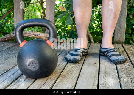 Concept de remise en forme de basse-cour - la formation de poids avec une forte concurrence de fer sur un patio en bois kettlebell Banque D'Images