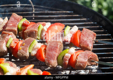 Boeuf, tomate, bacon et le poivre griller les brochettes sur un barbecue en été Banque D'Images