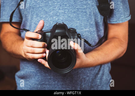 Close up of man hands holding photo reflex numérique - Photographie l'homme avec l'appareil photo Banque D'Images