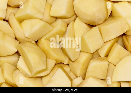 Pommes de terre pelées et coupées en dés dans une passoire en préparation comme ingrédient pour la cuisson d'un repas. Banque D'Images