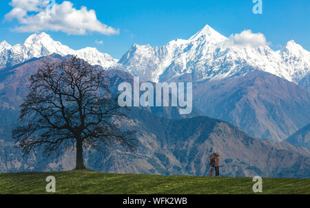 Garhwal Himalaya montagnes avec paysage pittoresque et couple de touristes profitant de la vue et en cliquant sur les photos à l'Uttarakhand, Inde Banque D'Images