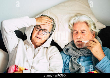 Couple de vieux âgés de hauts fonctionnaires à la maison avec la maladie maladie froide saison hiver s'asseoir sur la sof ensemble pour toujours - problèmes de santé pour les retraités Banque D'Images