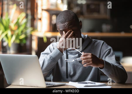 Fatigué a souligné black guy enlever verres sentir la fatigue oculaire Banque D'Images