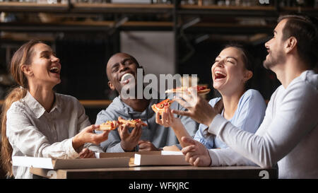 Professionnels divers friends laughing at drôle partager pizza Banque D'Images