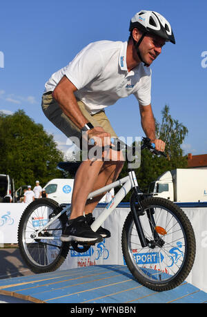 31 août 2019, Berlin : Randonnée à Vélo : l'UCI Europaserie - Allemagne Tour, 3ème étape, Göttingen - Eisenach (189, 00 km). L'ancien coureur cycliste allemand Jens Voigt rides vers le bas un obstacle avec une bicyclette au cours de la 'kinder sport mini tour'. Photo : Bernd Thissen/dpa dpa : Crédit photo alliance/Alamy Live News Banque D'Images