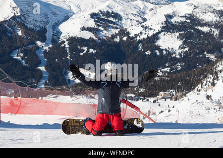 Snowboarder assis sur moment de détente dans la station de ski des Alpes italiennes - Hiver Sport Concept avec personne au sommet de la montagne prêt à rouler vers le bas Banque D'Images