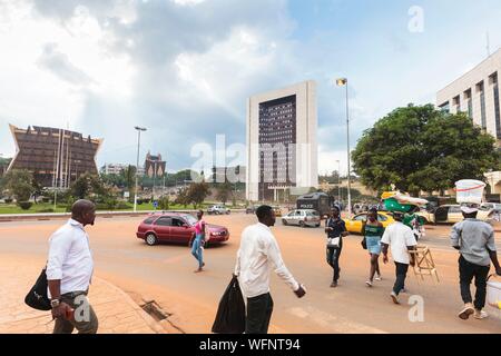 Cameroun, région Centre, Département du Mfoundi, Yaoundé, centre-ville, la place du 20 mai, les voitures et les gens en face du bureau du Premier Ministre et du bâtiment en face du Ministère des biens de l'Etat, des enquêtes et des régimes fonciers Banque D'Images