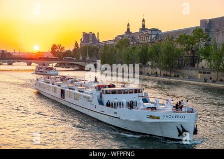 France, Paris, région classée au Patrimoine Mondial de l'UNESCO, un navire de croisière festive passe par le Louvre au coucher du soleil Banque D'Images