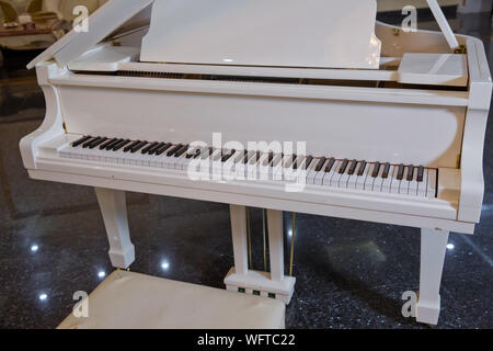Printemps décoration piano piano blanc .et président . piano blanc dans le hall pour vous détendre .Piano conner et jouer de la musique. Banque D'Images